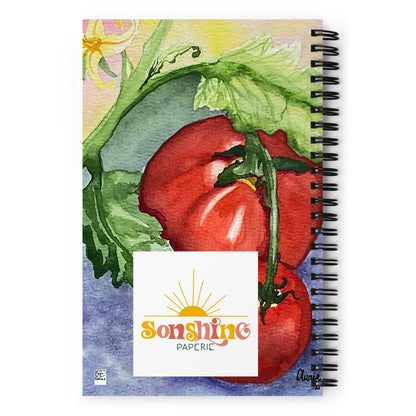 A spiral-bound notebook featuring a watercolor illustration of red tomatoes on the cover, with a white label reading 'Sunshine Paperie' in the center and a black spiral binding along the right edge.