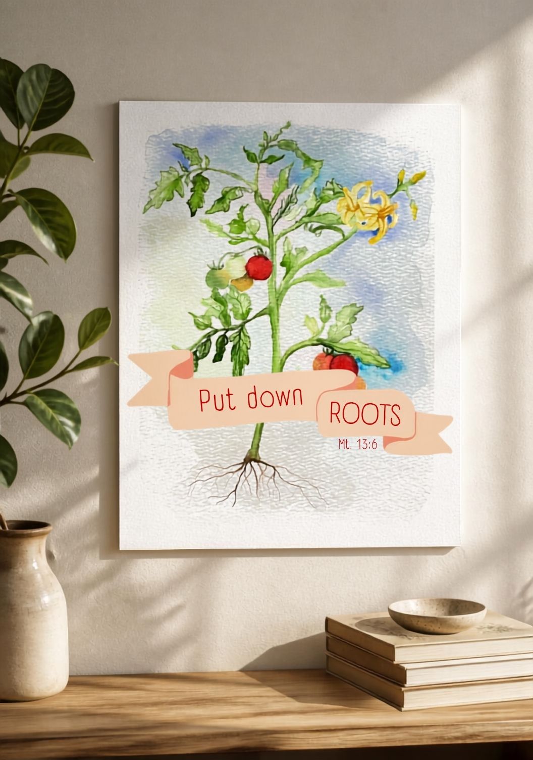A framed botanical art print featuring a tomato plant with the text 'Put down ROOTS Mt 13:6' on a peach banner, displayed on a wall above a wooden shelf with books and a plant.